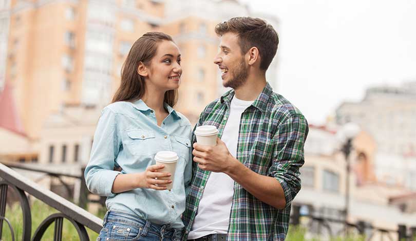 couple man girl hold cup of coffee in street
